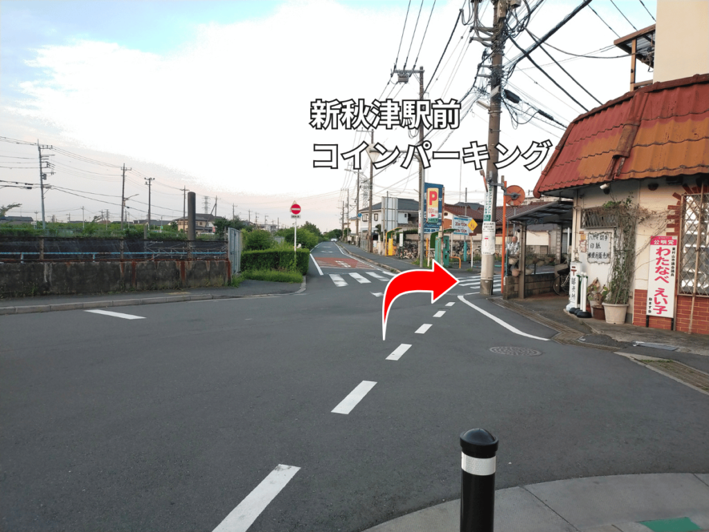 新秋津駅前コインパーキング前の交差点。右へ曲がる道順を示す赤い矢印