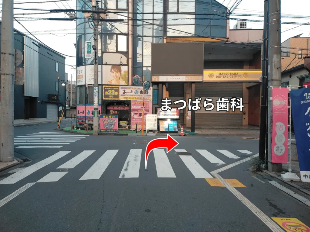 まつばら歯科前の交差点。右に曲がる道順を示す赤い矢印。