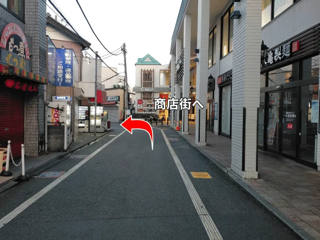 秋津商店街へ続く道。入口を示す赤い矢印。