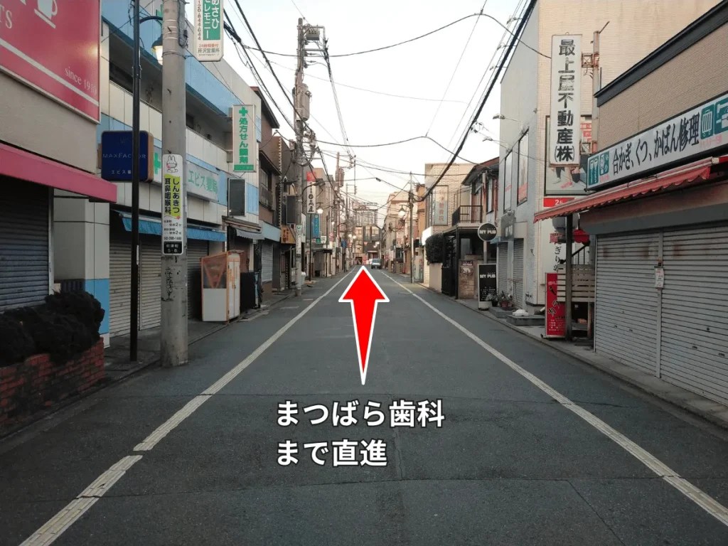 秋津商店街。まつばら歯科までの、直進方向を示す赤い矢印。