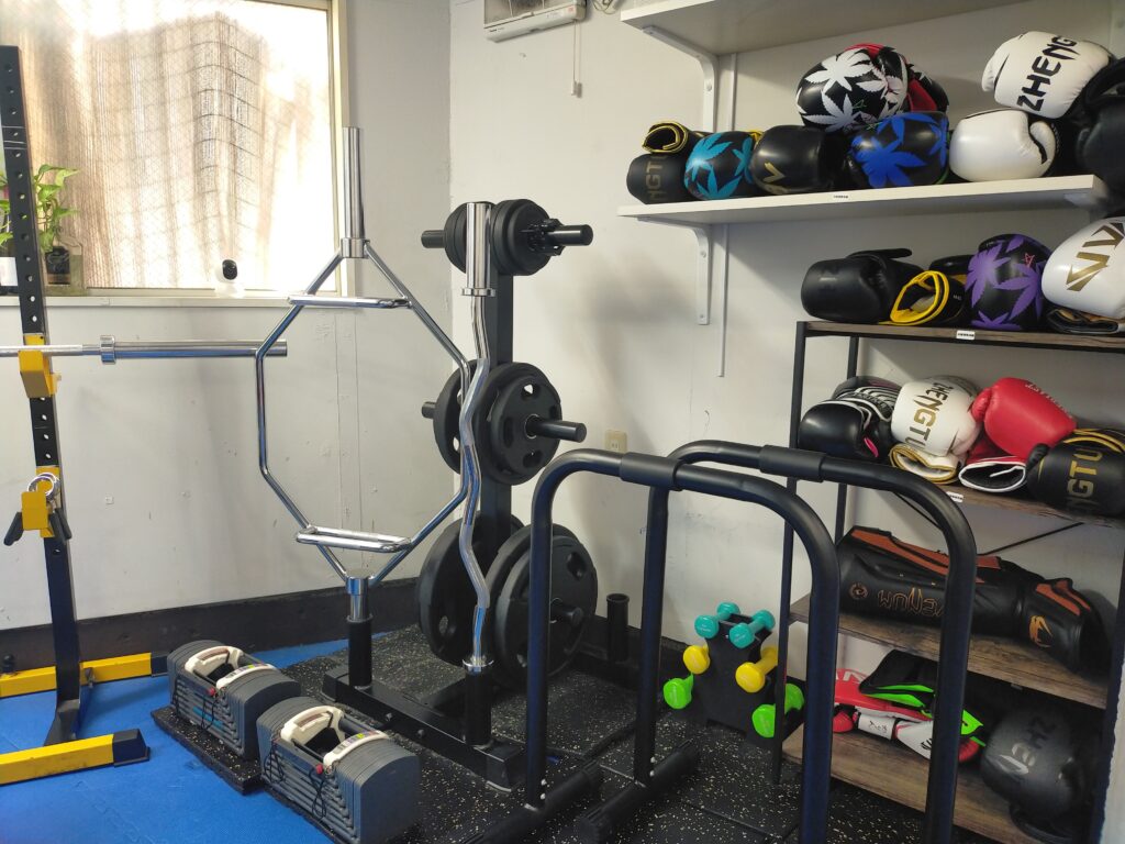 可変式ダンベルやボクシンググローブなどが整理されたトレーニング器具の収納棚